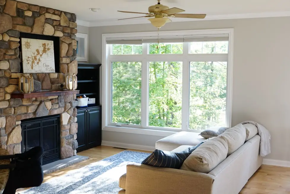 Living room with a stone fireplace and light gray walls, freshly painted