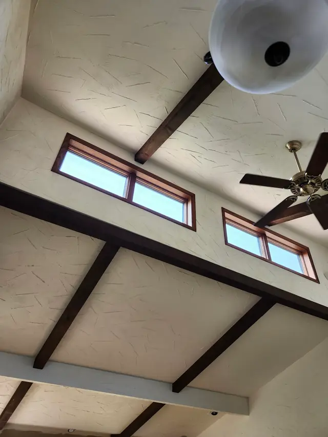 A vaulted ceiling with exposed beams and clerestory windows
