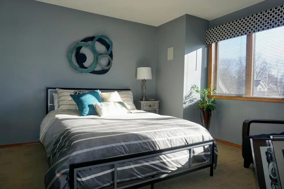 A bedroom repainted in slate blue with teal accents and crisp white trim