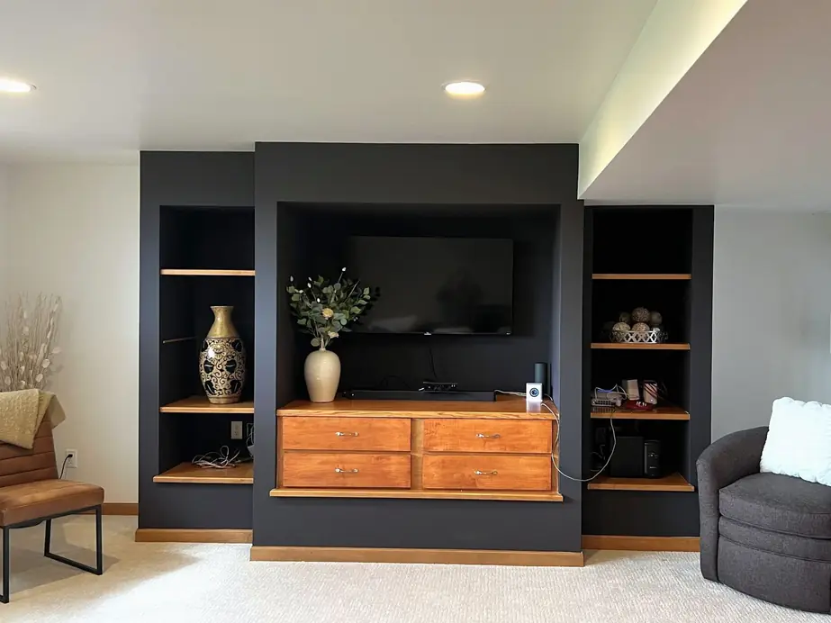 A built-in painted black with natural wood drawers