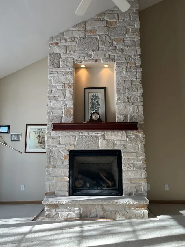 A stacked-stone fireplace wall in a vaulted room